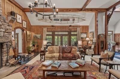 Spacious, inviting living area featuring a striking stone fireplace and artistic touches throughout.