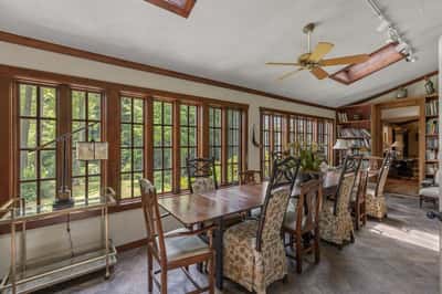 Bright sunroom with expansive windows, perfect for dining and enjoying garden views year-round.