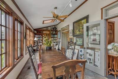 Bright and inviting dining area features ample natural light, a spacious table, and built-in bookshelves.