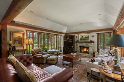 Spacious living area with a warm fireplace, abundant natural light, and inviting outdoor views.