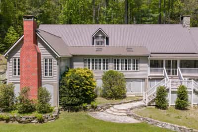 Nestled among trees, this unique property features ample outdoor space and distinctive architectural details.