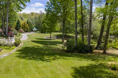 Spacious grounds feature lush greenery and a tranquil pond, perfect for outdoor gatherings and relaxation.