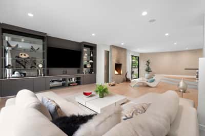 Spacious living area featuring a contemporary fireplace, sleek storage, and large windows for abundant natural light.