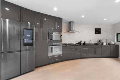 Modern kitchen featuring sleek cabinetry, high-end appliances, and a unique curved design for optimal functionality.