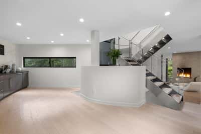 Contemporary open-concept living space featuring modern finishes, ample natural light, and a striking staircase design.
