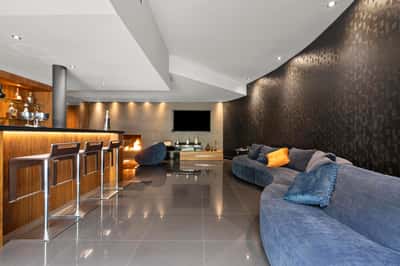 Modern open-concept living space featuring a sleek bar area and inviting, curved seating for relaxation.