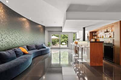 Contemporary open-concept living space with curved seating, sleek bar area, and seamless outdoor access.