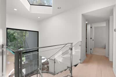 Bright and airy stairwell features large windows and modern railings, creating an inviting atmosphere.