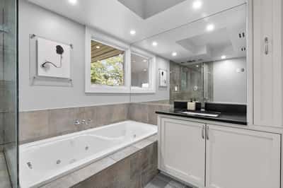 Bright and spacious bathroom featuring a large soaking tub, dual sinks, and modern fixtures.