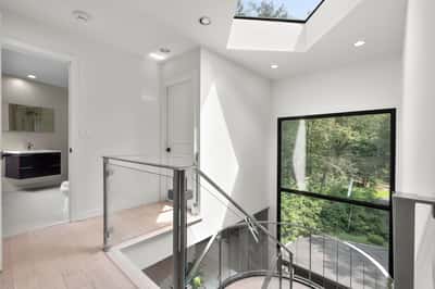 Bright and inviting foyer features modern design elements and abundant natural light, overlooking lush greenery.