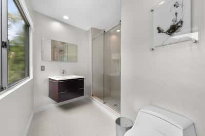 Modern bathroom featuring sleek fixtures, ample natural light, and a spacious walk-in shower for ultimate comfort.