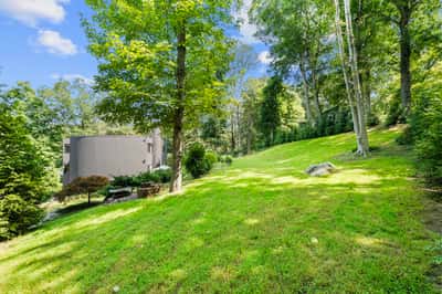 Expansive, wooded lot with gentle slopes, offering ample space for outdoor activities and future development.