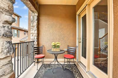Enjoy morning coffee on this inviting balcony with a cozy table and scenic views.