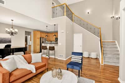Spacious open living area features high ceilings, modern kitchen, and abundant natural light throughout.