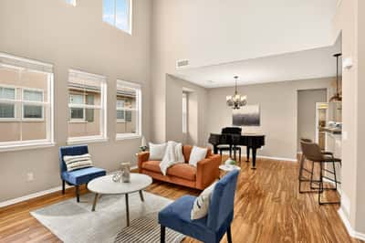 Light-filled living space featuring high ceilings and an inviting blend of modern and comfortable furnishings.