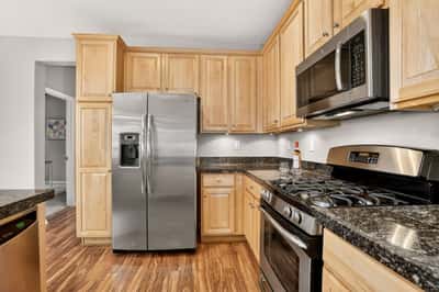 Modern kitchen featuring stainless steel appliances, ample cabinetry, and sleek granite countertops for a functional cooking space.