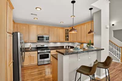 Modern kitchen featuring sleek stainless steel appliances, granite countertops, and a convenient breakfast bar.