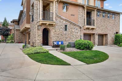 Beautifully designed townhome featuring stone accents, well-maintained landscaping, and convenient garage access in a desirable neighborhood.