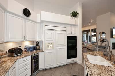 Updated Scottsdale kitchen with double ovens, granite counters, custom cabinetry, and wine fridge designed for both entertaining and functionality.