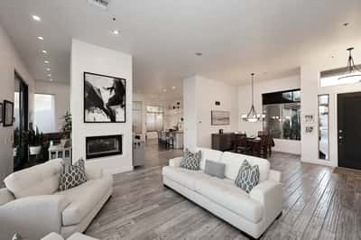 Open-concept living and dining space with fireplace, wood flooring, and modern finishes creates a versatile Scottsdale entertaining area.