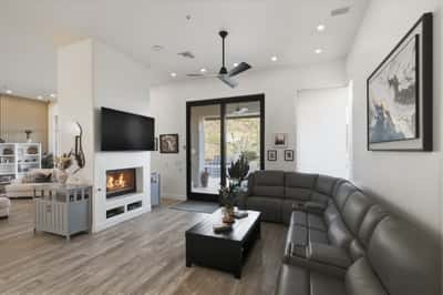 Inviting family room with fireplace, ceiling fan, and patio access offers comfortable Scottsdale living with indoor-outdoor flow.