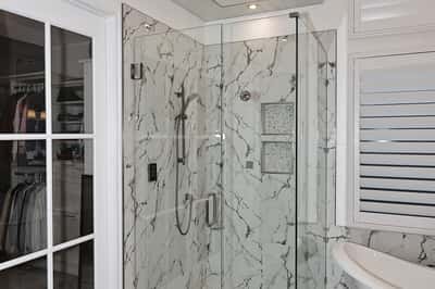 Sleek glass-enclosed shower with marble tile and upgraded fixtures adds contemporary luxury to this Scottsdale bathroom.