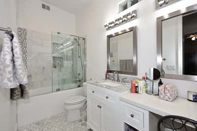 Updated bathroom with tiled shower, sleek vanity, and contemporary lighting enhances functionality and style in this Scottsdale home.