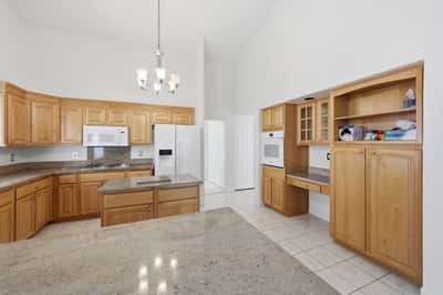 Spacious kitchen with built-in wall oven, custom cabinetry, and open design offers timeless style and practical functionality in this Peoria home.