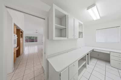 Versatile office space with built-in cabinetry and expansive work surfaces is perfect for remote work, hobbies, organization, or creative pursuits.