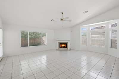 Spacious living area with oversized windows and fireplace offers bright interiors and a welcoming atmosphere in this beautifully maintained Peoria property.