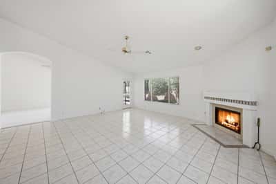 Fireplace-centered family room with open design and natural light provides a cozy yet spacious setting for entertaining and relaxing year-round.