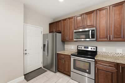 Beautiful kitchen showcasing stainless steel appliances, granite work surfaces, and rich cabinetry. Designed for efficiency and style, this space serves as the heart of the home.