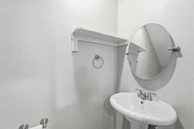 Convenient guest powder room featuring neutral finishes and easy accessibility. A valuable feature that adds comfort and functionality for homeowners and visitors alike.