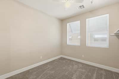 Secondary bedroom offering flexibility for guests, family members, or a home office. Neutral finishes and natural light create a comfortable and welcoming space.
