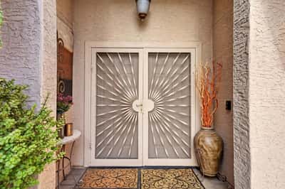 Elegant decorative security doors enhance the home's curb appeal while providing additional privacy and security. This inviting entryway sets the tone for the quality found throughout the residence.