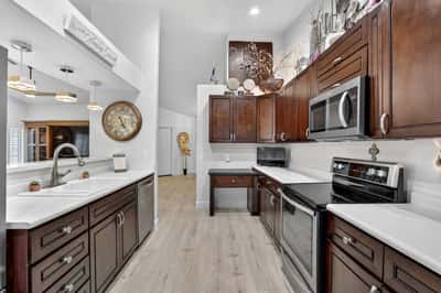 The kitchen opens to a sunny breakfast nook, creating an ideal space for casual dining and morning coffee. Rich cabinetry, stainless steel appliances, and generous workspace enhance everyday convenience.