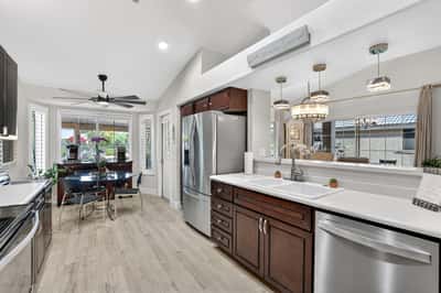 This updated kitchen blends style and functionality with stainless steel appliances, extensive cabinetry, and a casual dining area. Backyard views and natural light enhance the welcoming atmosphere.