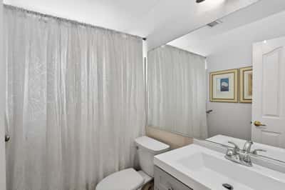 This well-maintained guest bathroom features modern finishes, a spacious vanity, and a convenient tub-shower combination. A bright and functional space for everyday use.