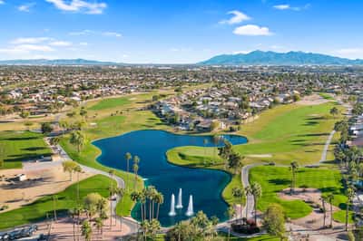 Panoramic aerial views capture lakes, fairways, palm trees, and expansive green spaces that define this impressive golf course community in Goodyear.