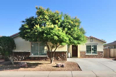 This attractive Buckeye home welcomes you with mature shade trees, stone-accented architecture, desert landscaping, and a spacious driveway leading to the attached two-car garage. Exceptional curb appeal makes a lasting first impression.