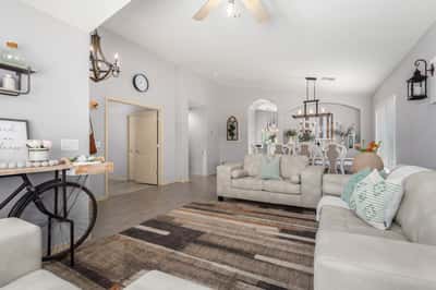 Featuring vaulted ceilings, abundant windows, updated flooring, and an open layout, this bright living room provides the perfect place to relax, entertain, or spend time with family.