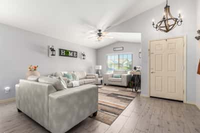 Bright windows, vaulted ceilings, updated flooring, and tasteful finishes make this inviting living room an ideal space for relaxing while enjoying the home's open-concept design.