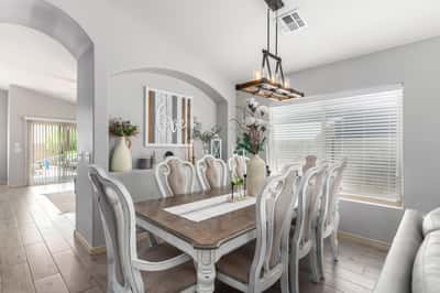 Gather family and friends in this spacious dining room featuring vaulted ceilings, designer lighting, updated flooring, and an open-concept layout that connects beautifully with the home's main living areas.