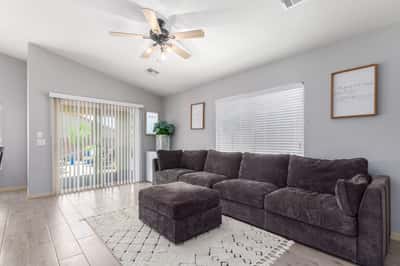 Relax in this inviting family room featuring large windows, ceiling fan, updated flooring, and direct access to the backyard patio. The open layout makes entertaining effortless while maximizing natural light.