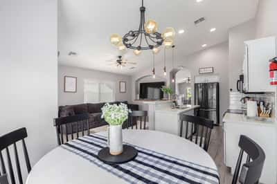 The open dining area overlooks the modern kitchen and spacious family room, creating an ideal layout for entertaining. Updated lighting, soaring ceilings, and contemporary finishes enhance the home's appeal.