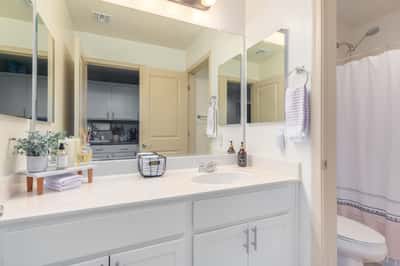 The guest bathroom offers a spacious vanity with white cabinetry, ample storage, and a full tub and shower combination. Bright finishes create a fresh, move-in-ready feel.