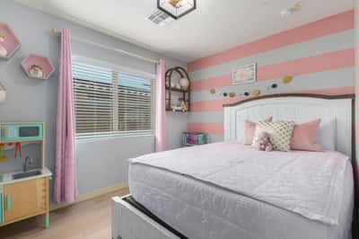 This charming secondary bedroom features updated flooring, large windows, and flexible space perfect for children, guests, or a home office, adding versatility to this beautiful Buckeye home.