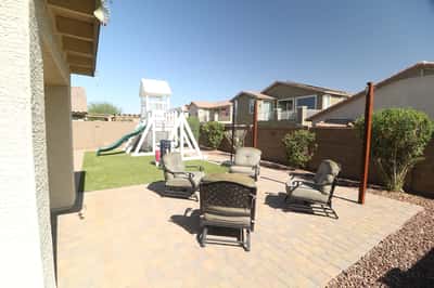 Host outdoor gatherings on the expansive paver patio surrounded by easy-care landscaping and artificial turf. The spacious backyard offers room to relax, entertain, and enjoy Arizona living in Buckeye.