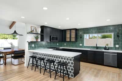 Gather around the oversized quartz island in this stunning chef's kitchen featuring custom cabinetry, designer finishes, stainless steel appliances, and an open layout perfect for entertaining family and guests.