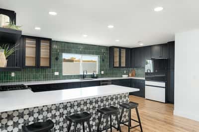 Rich cabinetry, striking tile accents, quartz countertops, and premium appliances combine to create a sophisticated kitchen designed for both everyday convenience and memorable entertaining.